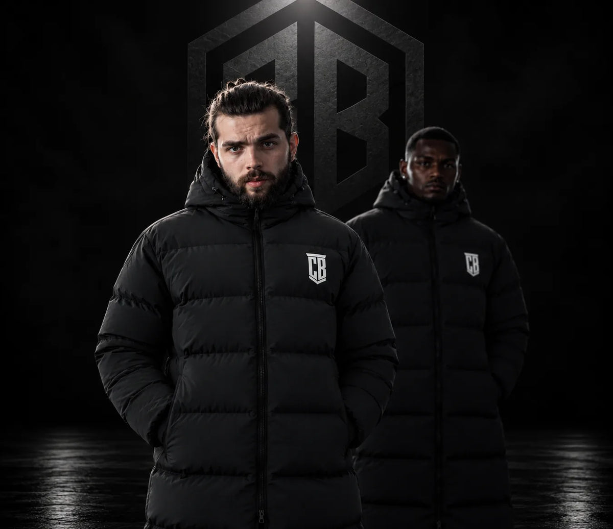 Two men wearing black long CB puffer parkas with the white CB crest